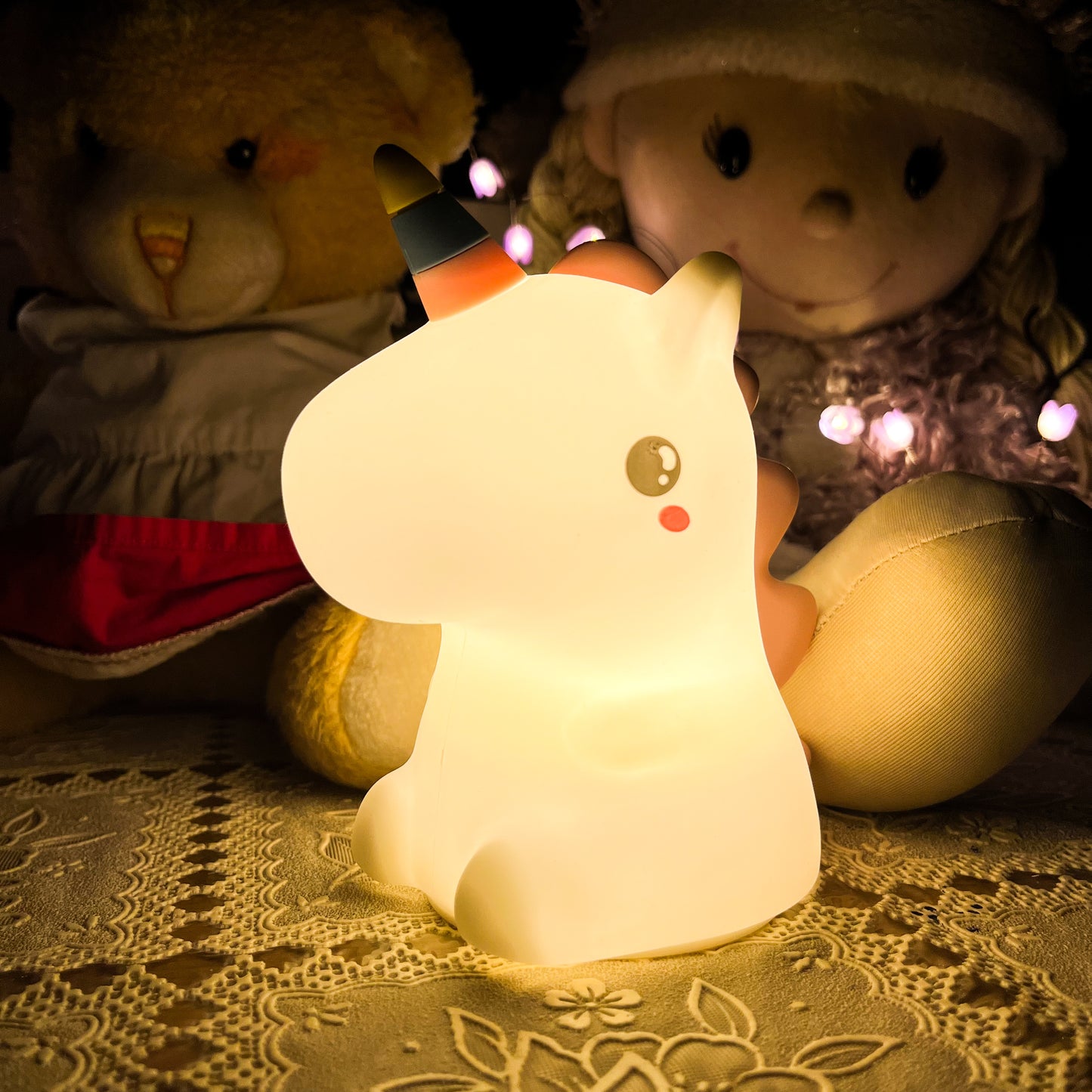 Cute animal-shaped night light with plush toys in the background